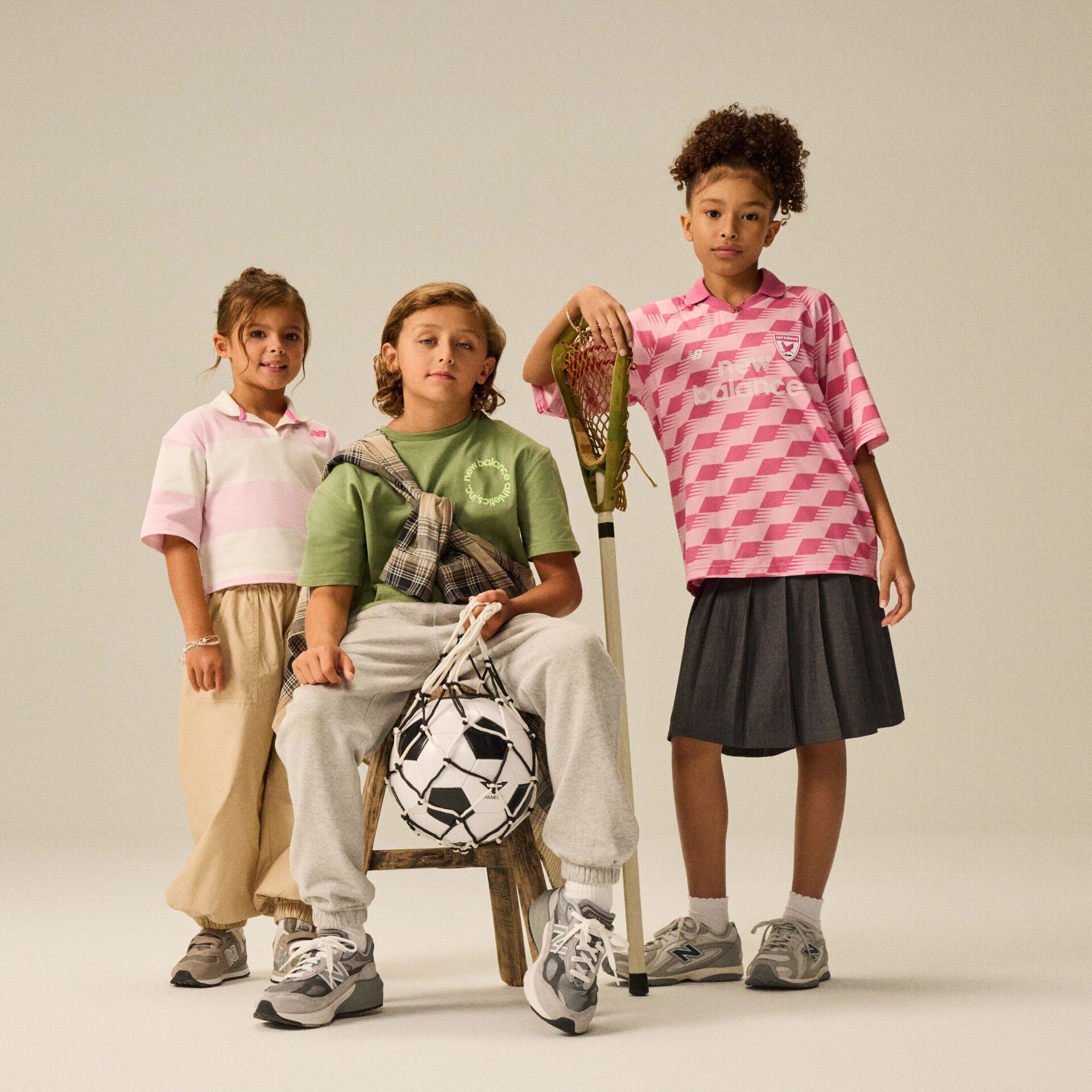Group of students sitting on a red bench in front of a beige background. 