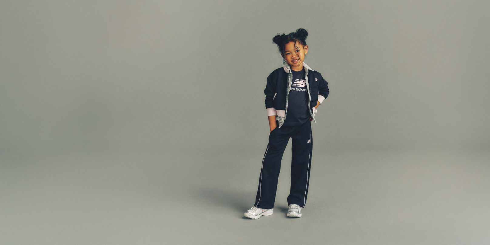 Child wearing New Balance clothes and shoes in a studio
