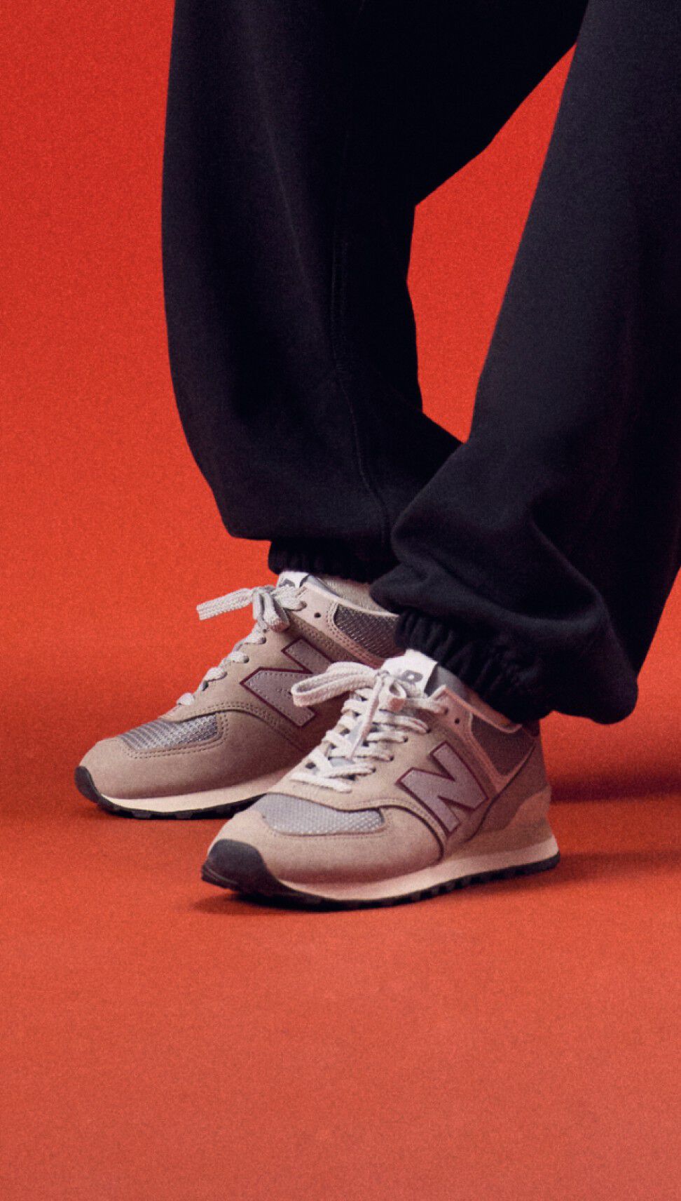 Young man stading on a red background wearing a black pants.